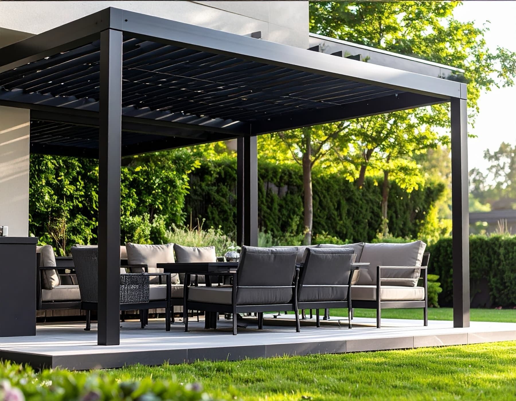Pergola med lamelltak över en uteplats med loungemöbler i kvällssol