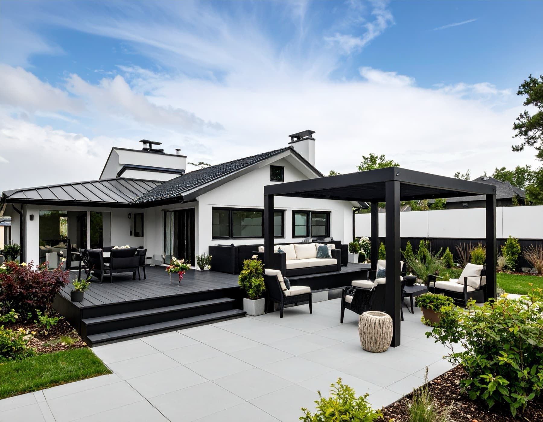 Fristående pergola på stengolv intill en vit villa