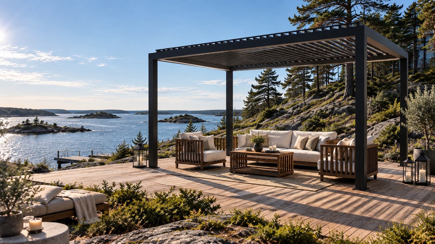 Fristående bioklimatisk pergola i antracit med lamelltak, över en loungegrupp på ett trädäck vid klipporna med utsikt över havet